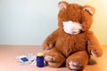 Teddy Bear wearing protective mask and surrounded by many packs of medicines. Quarantine and cure time.