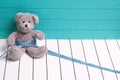 Teddy bear on a white wooden floor blue-green background with centimeter. Diet and weight loss in children Royalty Free Stock Photo