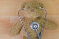 Teddy bear on wooden floor with stethoscope with earpieces in ea Royalty Free Stock Photo