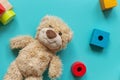 Teddy bear, wooden toys, blocks for preschooler children on a blue background. Toys for kindergarten, preschool or daycare.