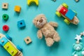 Teddy bear, wooden toys, blocks for preschooler children on a blue background. Toys for kindergarten, preschool or daycare.