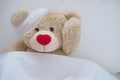 Teddy bear with a wound dress, wound and broken hands. Sleeping in bed. Sickness of children