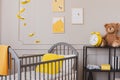 Teddy and yellow clock on industrial metal shelf in cute baby bedroom Royalty Free Stock Photo