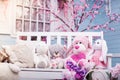 Teddy bears, Bunny and plush poodle sitting on white wooden bench.