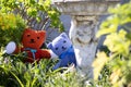Teddy bears hiding behind plants in a garden