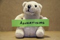 Teddybear holding advertising.