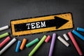 TEEM. Direction arrow with text on a dark chalkboard background Royalty Free Stock Photo