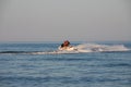 Teen age boy skiing on water scooter. Young man on personal watercraft in tropical sea. Active summer vacation for