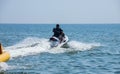 Teen age boy skiing on water scooter. Young man on personal watercraft in tropical sea. Active summer vacation for