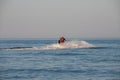 Teen age boy skiing on water scooter. Young man on personal watercraft in tropical sea. Active summer vacation for