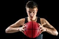 Teen basketball player holding ball.