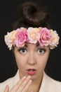 Teen beauty wearing a floral crown with a surprised expression