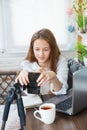 Teen blogger influencer recording video blog. Concept speaking looking at smartphone on tripod at home table. Teenager Royalty Free Stock Photo