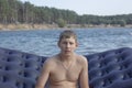 Teen with blonde hair sitting on an air mattress in water