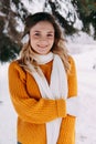 Teen blonde in a yellow sweater outside in winter. A teenage girl on a walk in winter clothes in a snowy forest Royalty Free Stock Photo