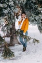 Teen blonde in a yellow sweater outside in winter. A teenage girl on a walk in winter clothes in a snowy forest Royalty Free Stock Photo