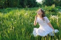 Teen blowing seeds from a dandelion flower in a spring park Royalty Free Stock Photo