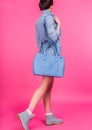 Teen in blue boots and denim suit holding blue leather handbag