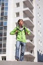 Teen boy with backpack walking in city street Royalty Free Stock Photo