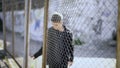 Teen boy behind fence confinement, boarding school restrictions, broken future Royalty Free Stock Photo