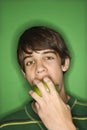 Teen boy biting apple.