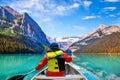 Teen boy canoeing on Lake Louise in Banff National Park of the Canadian Rockies with its glacier-fed turquoise lakes and Mount Royalty Free Stock Photo