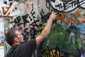 Teen boy concentrating on painting graffiti