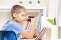 Boy distracting from online lesson and playing games, scrolling phone. Learning difficulties, online education at home Royalty Free Stock Photo