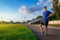 Teen boy boy does physical exercises at the stadium track, a soccer field with green grass - concept of sports and health