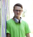 Teen boy with earphones near graffiti wall. Royalty Free Stock Photo