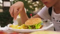 Teen boy eating hamburger and french fries in outdoor cafe. close-up Royalty Free Stock Photo