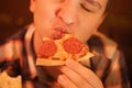 Teen boy eats pizza and enjoys it, closeup enjoying and savoring.