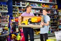 Teen boy with father visiting children toy store in search of big plastic car for gift