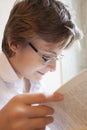 Teen boy in glasses reads a book Royalty Free Stock Photo