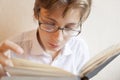 Teen boy in glasses reads a book Royalty Free Stock Photo