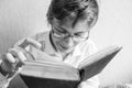 Teen boy in glasses reads a book Royalty Free Stock Photo