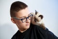 Teen boy in glasses with a Siamese Thai kitten