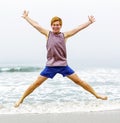 Teen boy jumps up at the beach Royalty Free Stock Photo