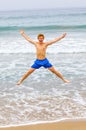 Teen boy jumps up the beach Royalty Free Stock Photo