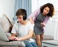 Teen boy with laptop oblivious to anxious mother Royalty Free Stock Photo