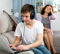 Teen boy with laptop oblivious to anxious mother