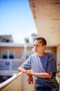 Teen Boy Leaning On Balcony Rail on Sunny Day Royalty Free Stock Photo