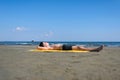 Teen boy lies on yellow towel and sunbathes on the beach.