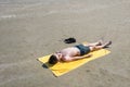 Teen boy lies on yellow towel and sunbathes on the beach. Traveling on an airplane with children. Concep