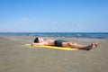 Teen boy lies on yellow towel and sunbathes on the beach. Traveling on an airplane with children.