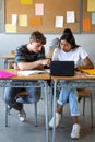 Teen boy and native american female high school students in class working together using laptop. Vertical. Royalty Free Stock Photo