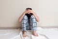 Teen boy in pajamas sitting on the floor near the wall Royalty Free Stock Photo