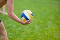 Teen boy playing beach volleyball. Volleyball player on the grass playing with the ball, a volleyball ball in his hand Royalty Free Stock Photo