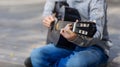 Teen boy plays black acoustic guitar on an autumn day Royalty Free Stock Photo