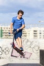 Teen boy rides his scooter at the skate park Royalty Free Stock Photo